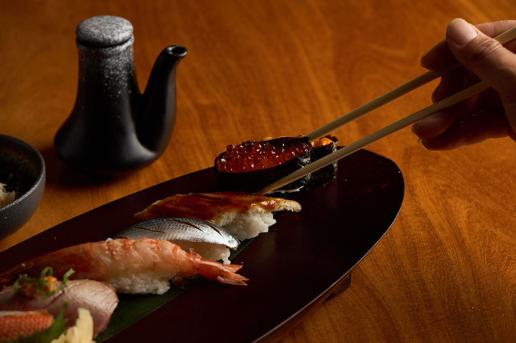 Picking up fresh nigiri with chopsticks at Anaba