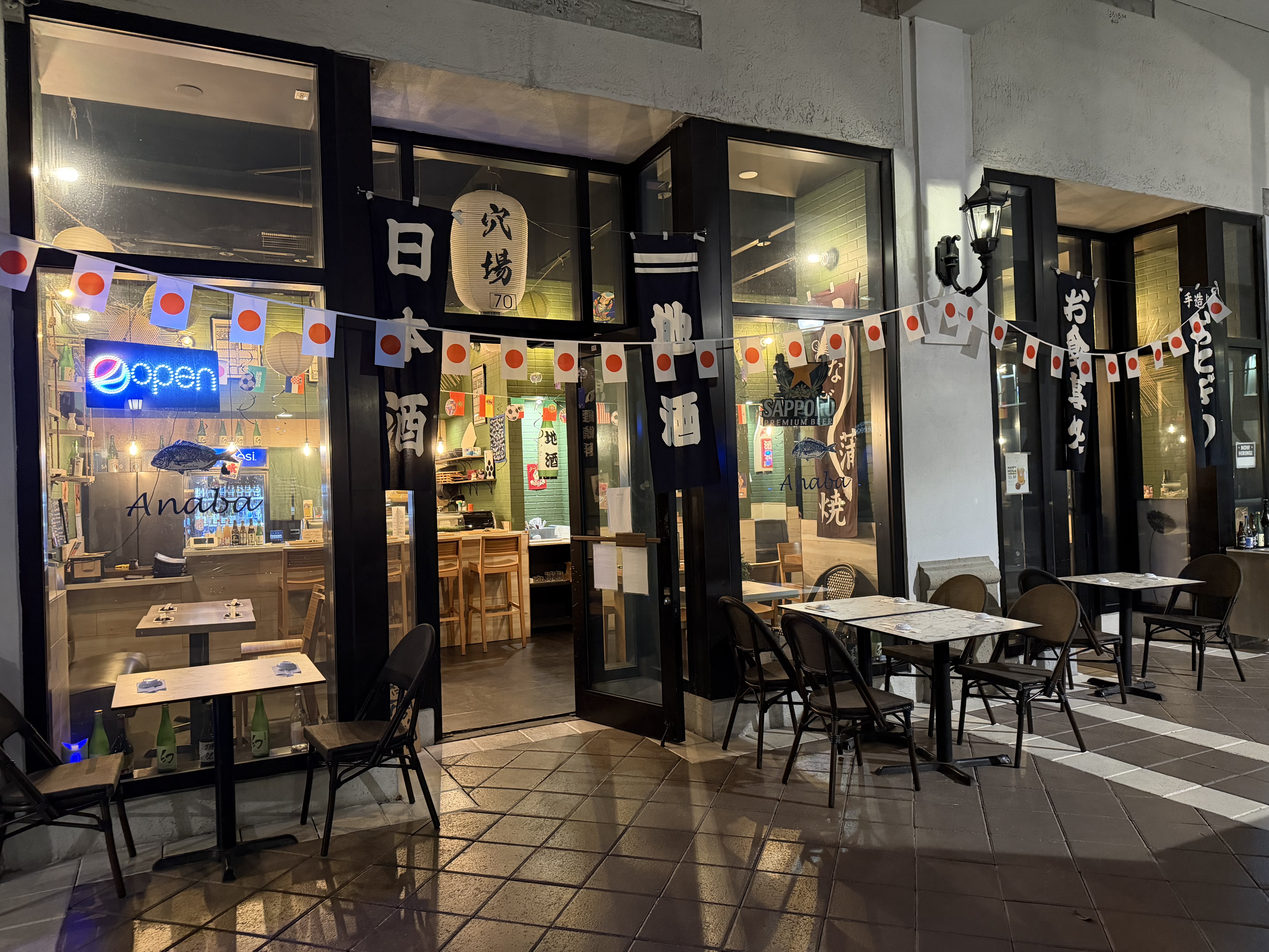 Anaba restaurant exterior at night — Japanese banners, lanterns, and outdoor seating on Aragon Ave